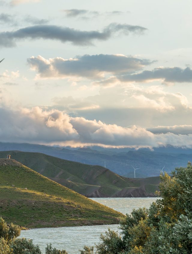 wind-power-turbine-hill-front-cloudy-sky